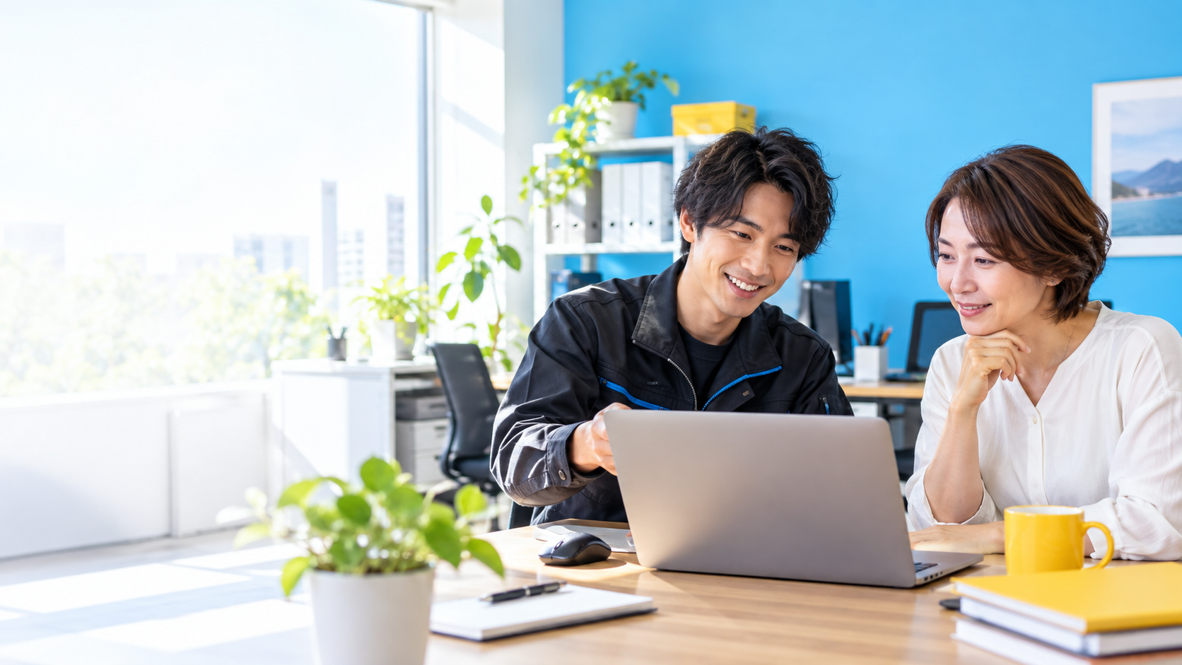 事業者とIT担当者がパソコンを見ながら相談する実写調の生成イメージ